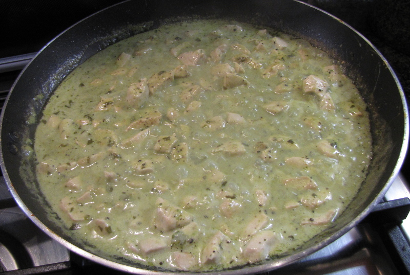 Simmering the chicken, pesto and coconut milk together